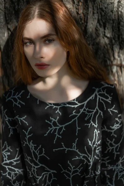 森の中の自然な場所にあるリネンのドレスに長い赤い髪の若い女性 — ストック写真