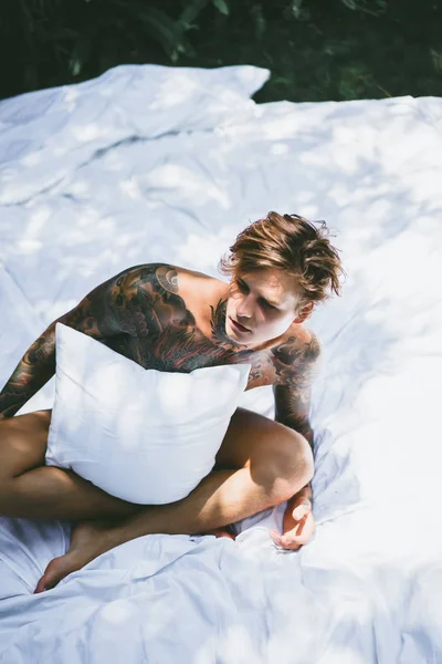 Young Handsome Tattooed Man Morning Bed Tosses Pillows Bed Garden — Stock Photo, Image