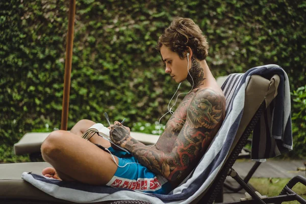 Jovem Tatuagens Usando Fones Ouvido Ouve Música Desenha Lápis Caderno — Fotografia de Stock