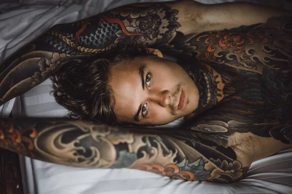 Dövmeli Yakışıklı Adam Yatakta Dinleniyor — Stok fotoğraf