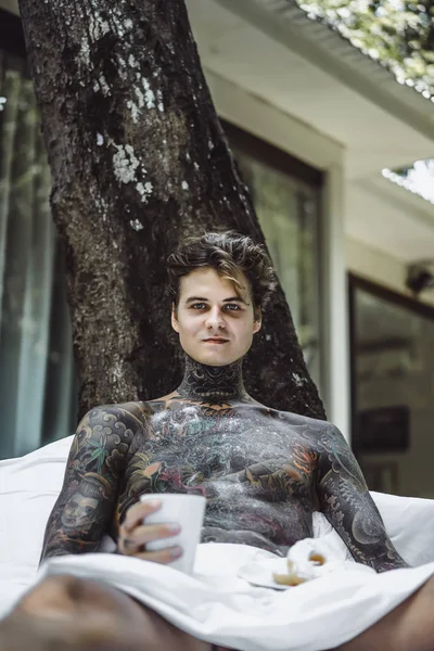 Young Handsome Tattooed Man Having Breakfast Bed Open Air Outdoors — Stockfoto