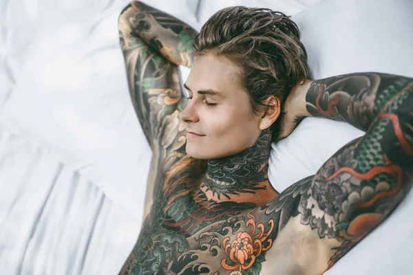 Dövmeli Yakışıklı Genç Adam Yatakta Dinleniyor — Stok fotoğraf