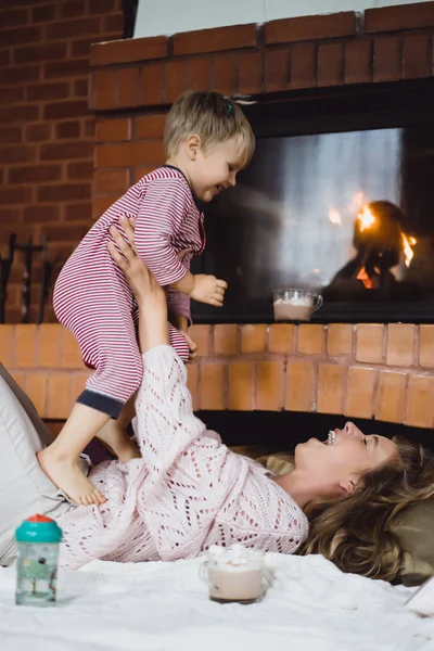 子どもを持つ若い女性 ママと息子は浮気 暖炉のそばの楽しい時を過す — ストック写真