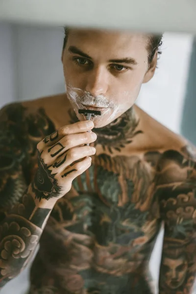 Jovem Bonitão Tatuado Manhã Faz Barba Frente Espelho Uma Navalha — Fotografia de Stock