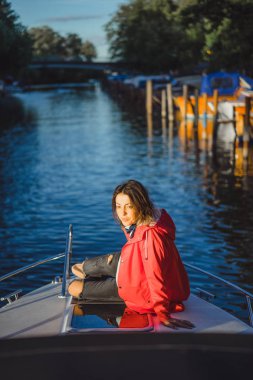 kırmızı bir yağmurluk güzel genç kadın ile özel yat gidiyor. Stockholm, İsveç