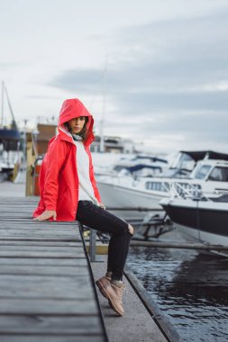 Yat limanında bir kırmızı pelerin güzel genç kadın. Stockholm, İsveç