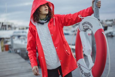 Yat limanında bir kırmızı pelerin güzel genç kadın. Stockholm, İsveç