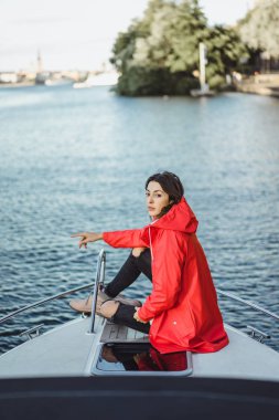 kırmızı bir yağmurluk güzel genç kadın ile özel yat gidiyor. Stockholm, İsveç