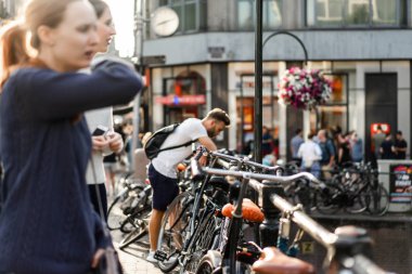 Bir insan bir sırt çantası ile Amsterdam sokaklarında yürüyor.