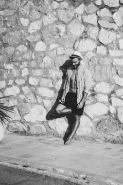 çizgili gömlekli, hasır şapka giyen bir adam, küçük bir İspanyol kasabasının sokaklarında yürüyor..