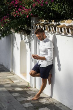 Beyaz gömlekli adam yazın açık havada kahve içer.