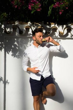 Beyaz gömlekli adam yazın açık havada kahve içer.