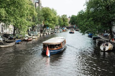 Amsterdam kanalları, tekneler su üstünde yürüyor