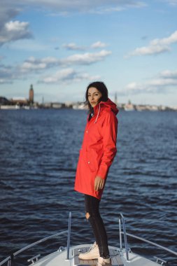 kırmızı bir yağmurluk güzel genç kadın ile özel yat gidiyor. Stockholm, İsveç