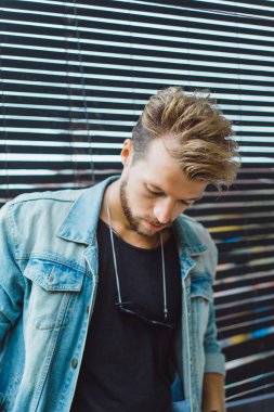 tropikal bir yerde, palmiye ağaçları ve yeşil, güneş gözlüklü bir arka plan üzerinde poz genç çekici adam