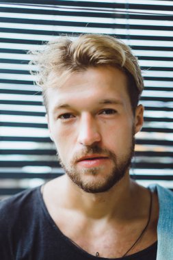 tropikal bir yerde, palmiye ağaçları ve yeşil, güneş gözlüklü bir arka plan üzerinde poz genç çekici adam