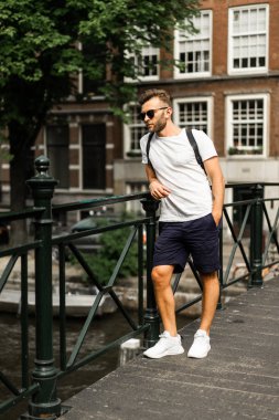 Amsterdam'da köprüde poz adam.