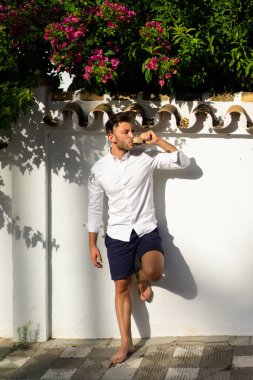 Beyaz gömlekli adam yazın açık havada kahve içer.