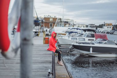 Yat limanında bir kırmızı pelerin güzel genç kadın. Stockholm, İsveç
