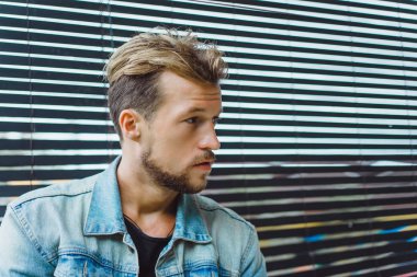 tropikal bir yerde, palmiye ağaçları ve yeşil, güneş gözlüklü bir arka plan üzerinde poz genç çekici adam