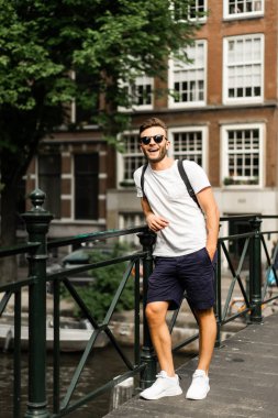 Amsterdam'da köprüde poz adam.