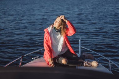 kırmızı bir yağmurluk güzel genç kadın ile özel yat gidiyor. Stockholm, İsveç