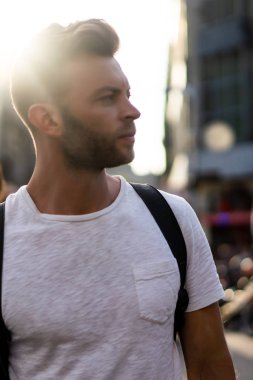 Bir insan bir sırt çantası ile Amsterdam sokaklarında yürüyor.