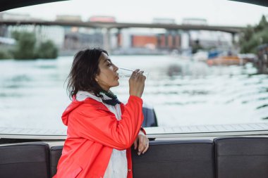 kırmızı bir yağmurluk güzel genç kadın ile özel yat gidiyor. Stockholm, İsveç