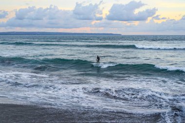 gökyüzü ve okyanus güzel günbatımı okyanus üzerinde. sörfçü bir dalga için bekliyor.