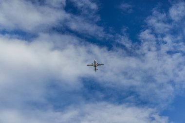 Mavi gökyüzünde bir jet uçağının görüntüsü.