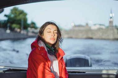 kırmızı bir yağmurluk güzel genç kadın ile özel yat gidiyor. Stockholm, İsveç