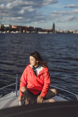 kırmızı bir yağmurluk güzel genç kadın ile özel yat gidiyor. Stockholm, İsveç