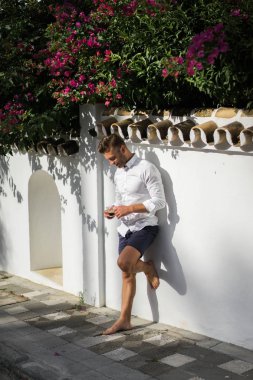 Beyaz gömlekli adam yazın açık havada kahve içer.