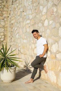 çizgili gömlekli, hasır şapka giyen bir adam, küçük bir İspanyol kasabasının sokaklarında yürüyor..