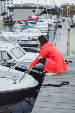 Yat limanında bir kırmızı pelerin güzel genç kadın. Stockholm, İsveç