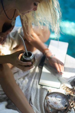 Çatıda mate çay içme uzun sarı saçlı güzel Hint hippi kız. Calabaza