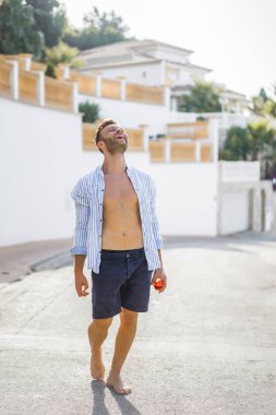 Kadehli gömlekli bir adam. Bir İspanyol kasabasında yaz tatili, açık hava.