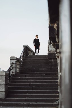 Yakışıklı atletik genç adam dışarıda egzersiz yapıyor.