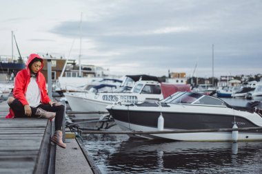 Yat limanında bir kırmızı pelerin güzel genç kadın. Stockholm, İsveç