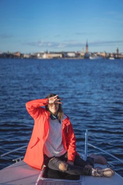 kırmızı bir yağmurluk güzel genç kadın ile özel yat gidiyor. Stockholm, İsveç