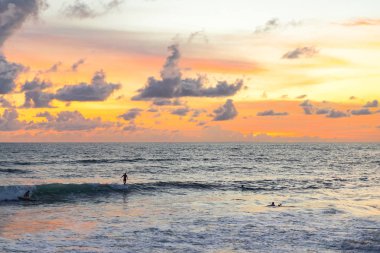 gökyüzü ve okyanus güzel günbatımı okyanus üzerinde. sörfçü bir dalga için bekliyor.