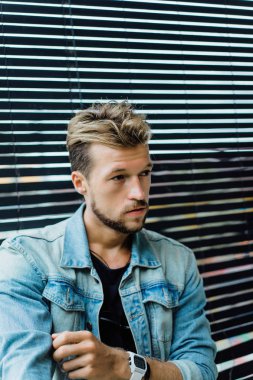 tropikal bir yerde, palmiye ağaçları ve yeşil, güneş gözlüklü bir arka plan üzerinde poz genç çekici adam