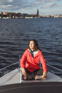 kırmızı bir yağmurluk güzel genç kadın ile özel yat gidiyor. Stockholm, İsveç