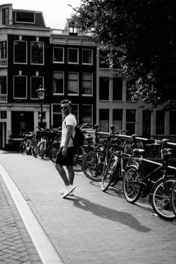 Bir insan bir sırt çantası ile Amsterdam sokaklarında yürüyor.