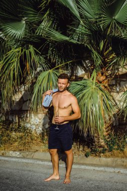 çizgili gömlekli, hasır şapka giyen bir adam, küçük bir İspanyol kasabasının sokaklarında yürüyor..