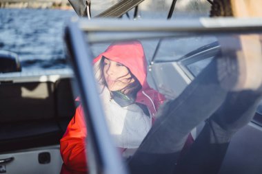 kırmızı bir yağmurluk güzel genç kadın ile özel yat gidiyor. Stockholm, İsveç