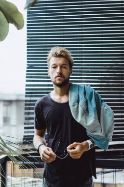 tropikal bir yerde, palmiye ağaçları ve yeşil, güneş gözlüklü bir arka plan üzerinde poz genç çekici adam