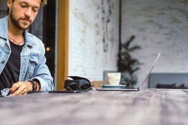 genç çekici iş adamı için bir dizüstü bilgisayar, bir kafe eserlerinde kahve içiyor.