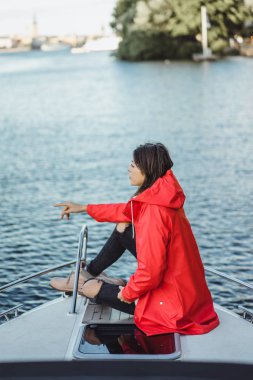 kırmızı bir yağmurluk güzel genç kadın ile özel yat gidiyor. Stockholm, İsveç