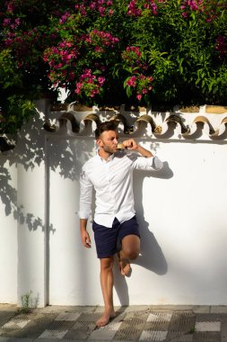 Beyaz gömlekli adam yazın açık havada kahve içer.